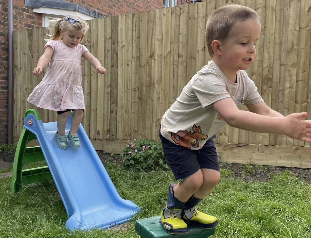 Two children jumping practicing gross motor skills development