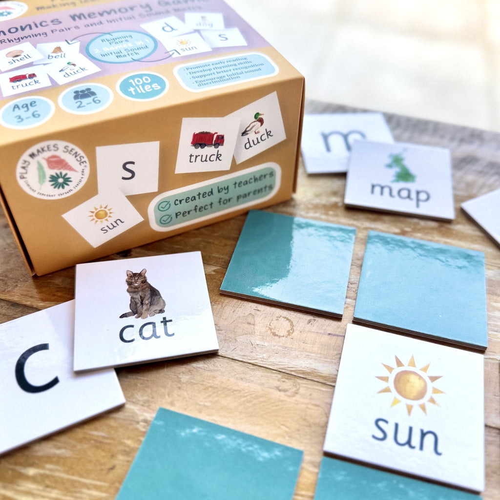 Initial sounds phonics tiles laid out on table with box in background 