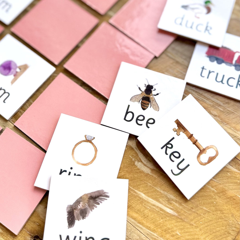 Rhyming pairs tiles laid out on table. Bee and key tiles, duck and truck tiles and ring and wing tiles. 