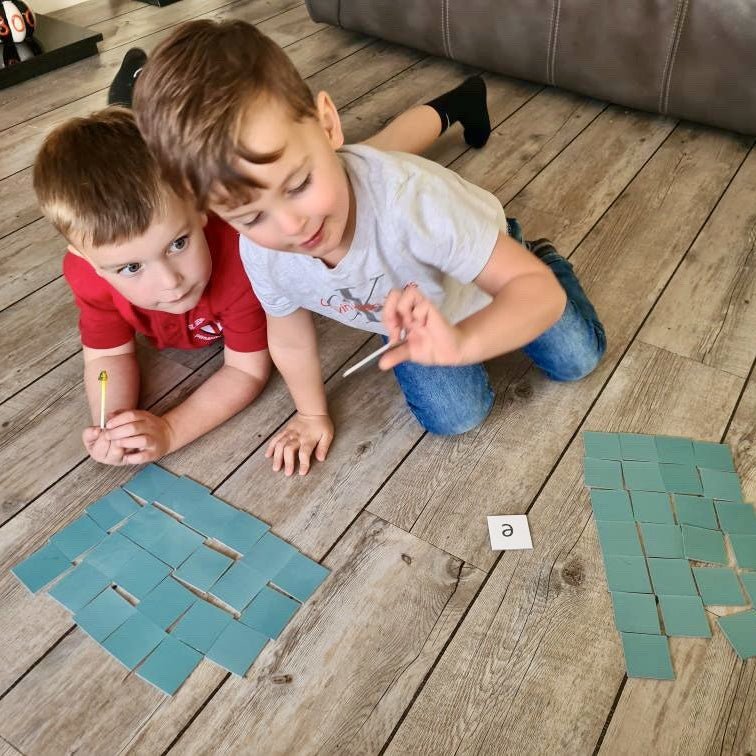 The children on a wooden floor playing initial sound match
