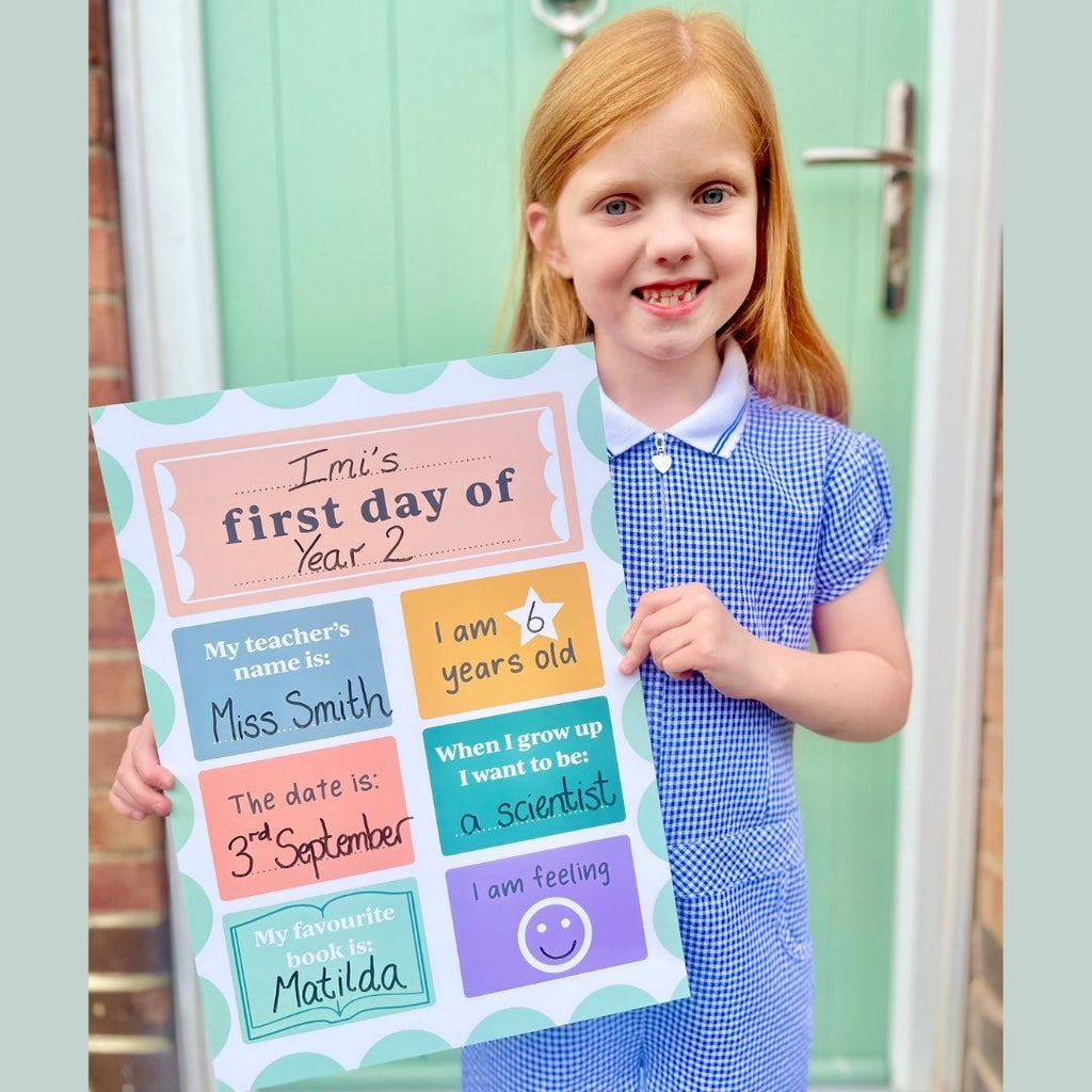 Child holding First Day of School Board